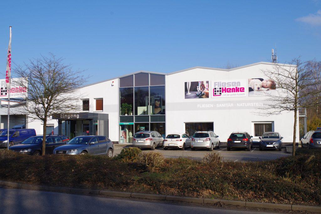 Fliesen-Henke-Gebäude mit Eingang und Parkplätzen in Stelle